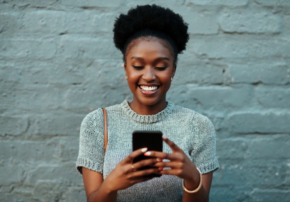Person smiling at phone.