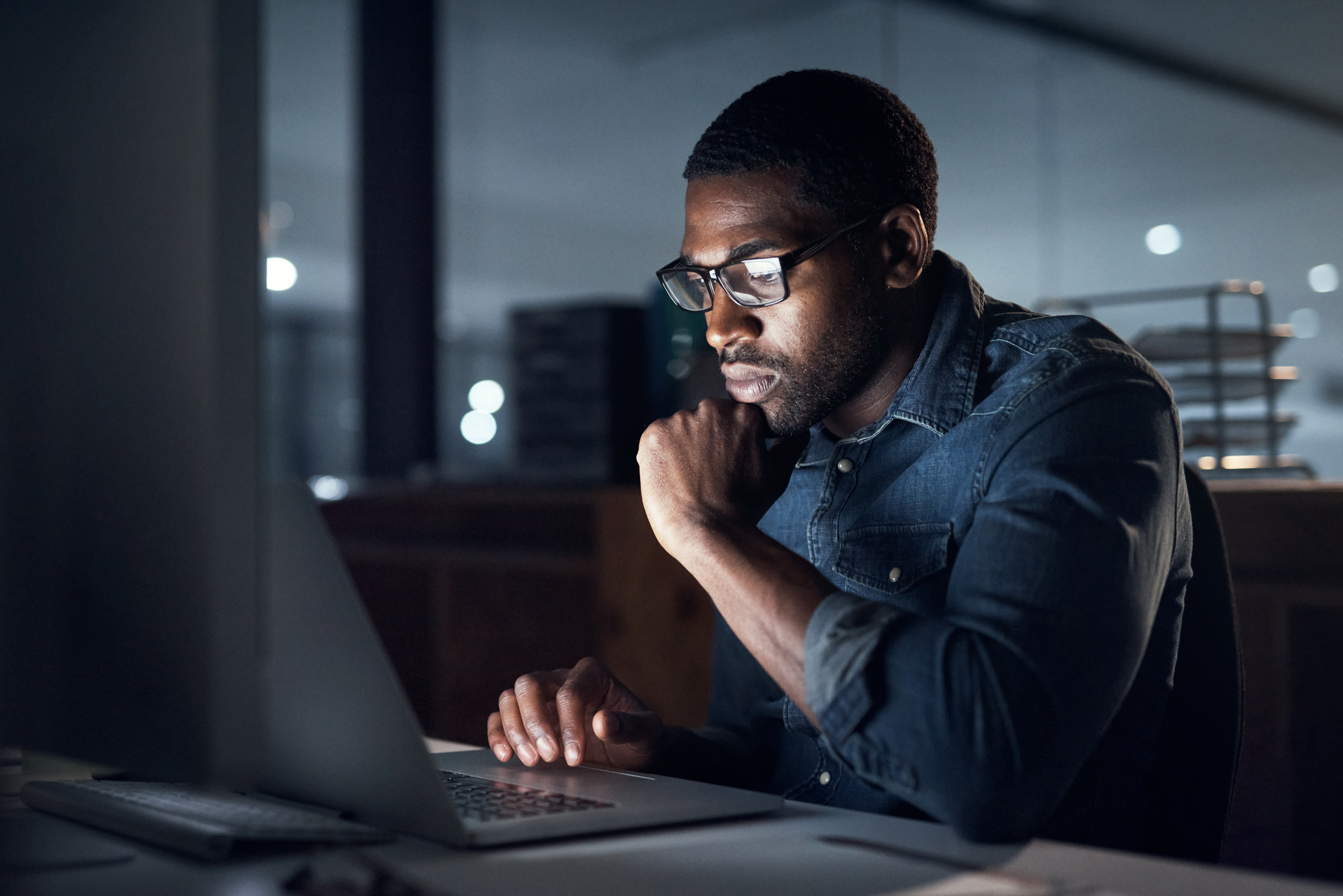 person using a laptop during a late night in a modern office