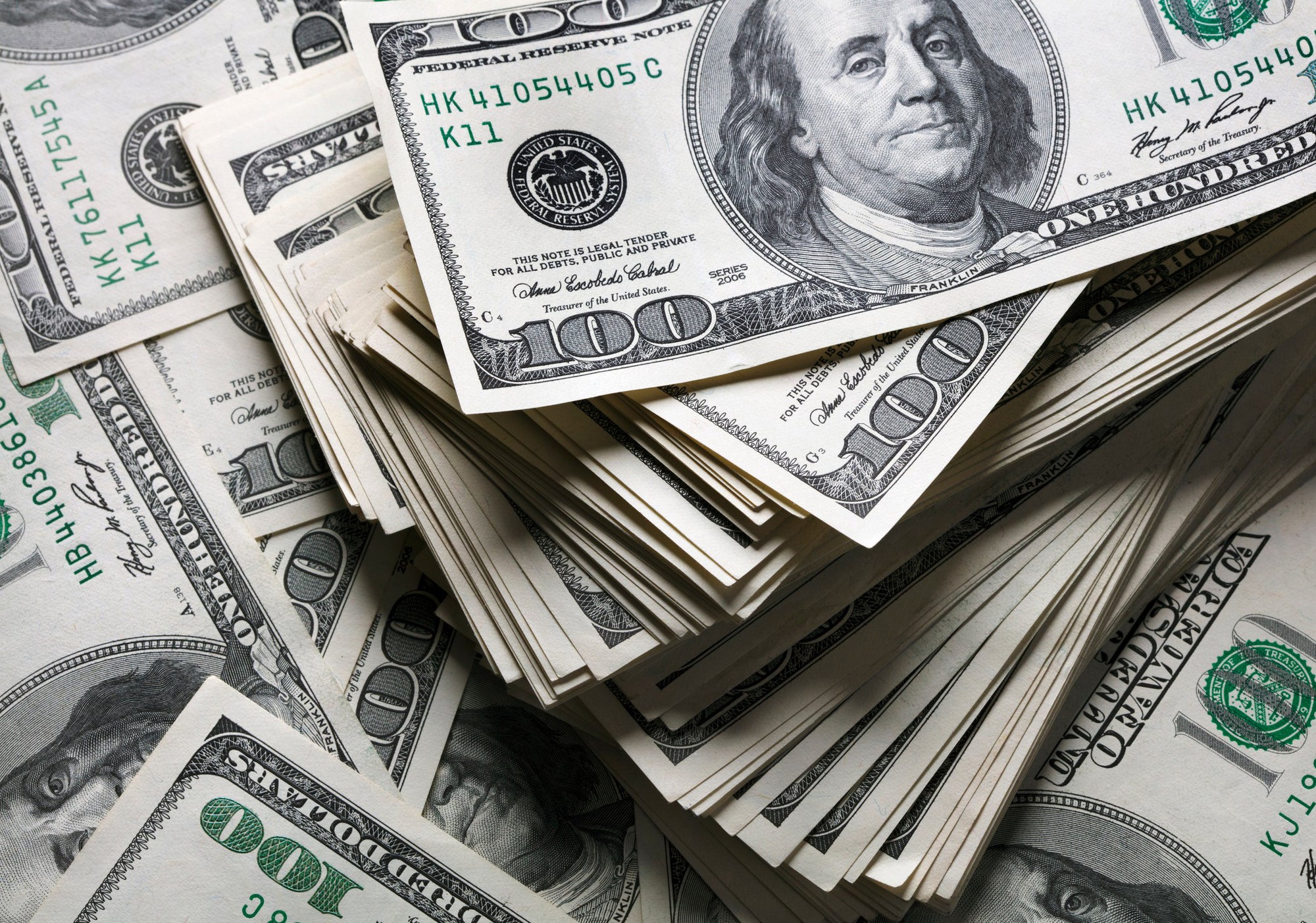 Messy piles of hundred dollar bills.