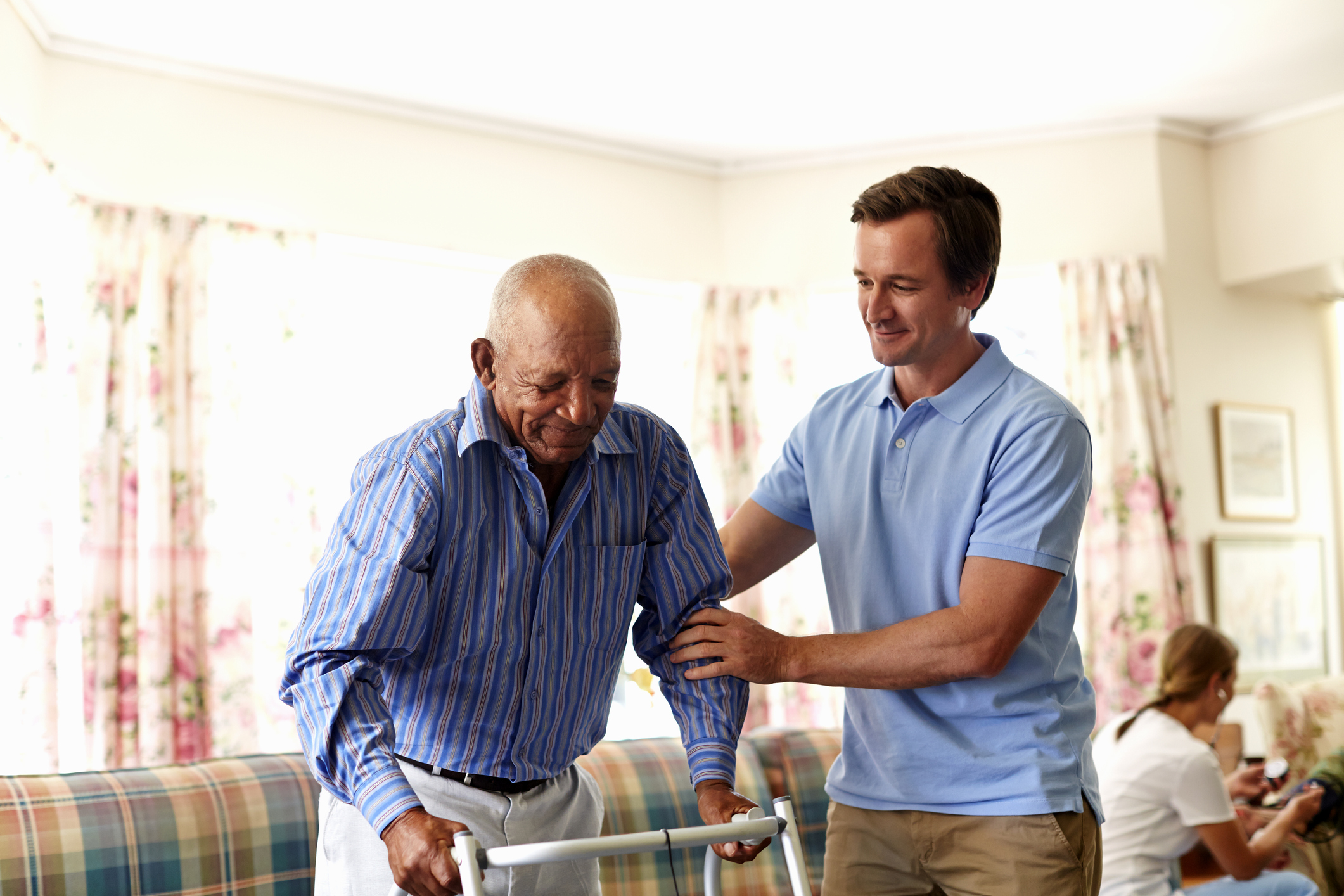 22_06_27 A person helping another person with a walker _GettyImages-489582797