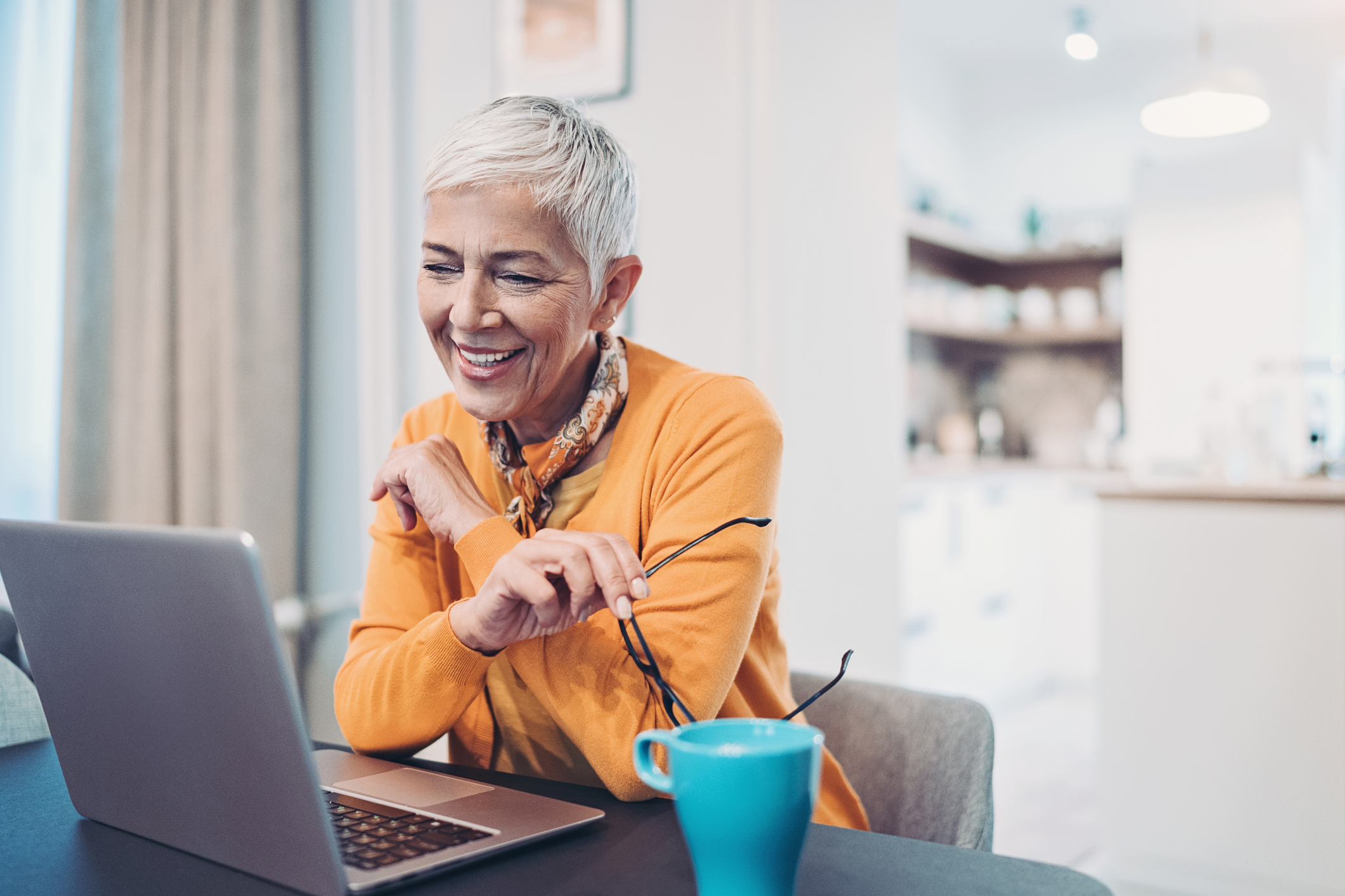 A smiling person at a laptop.