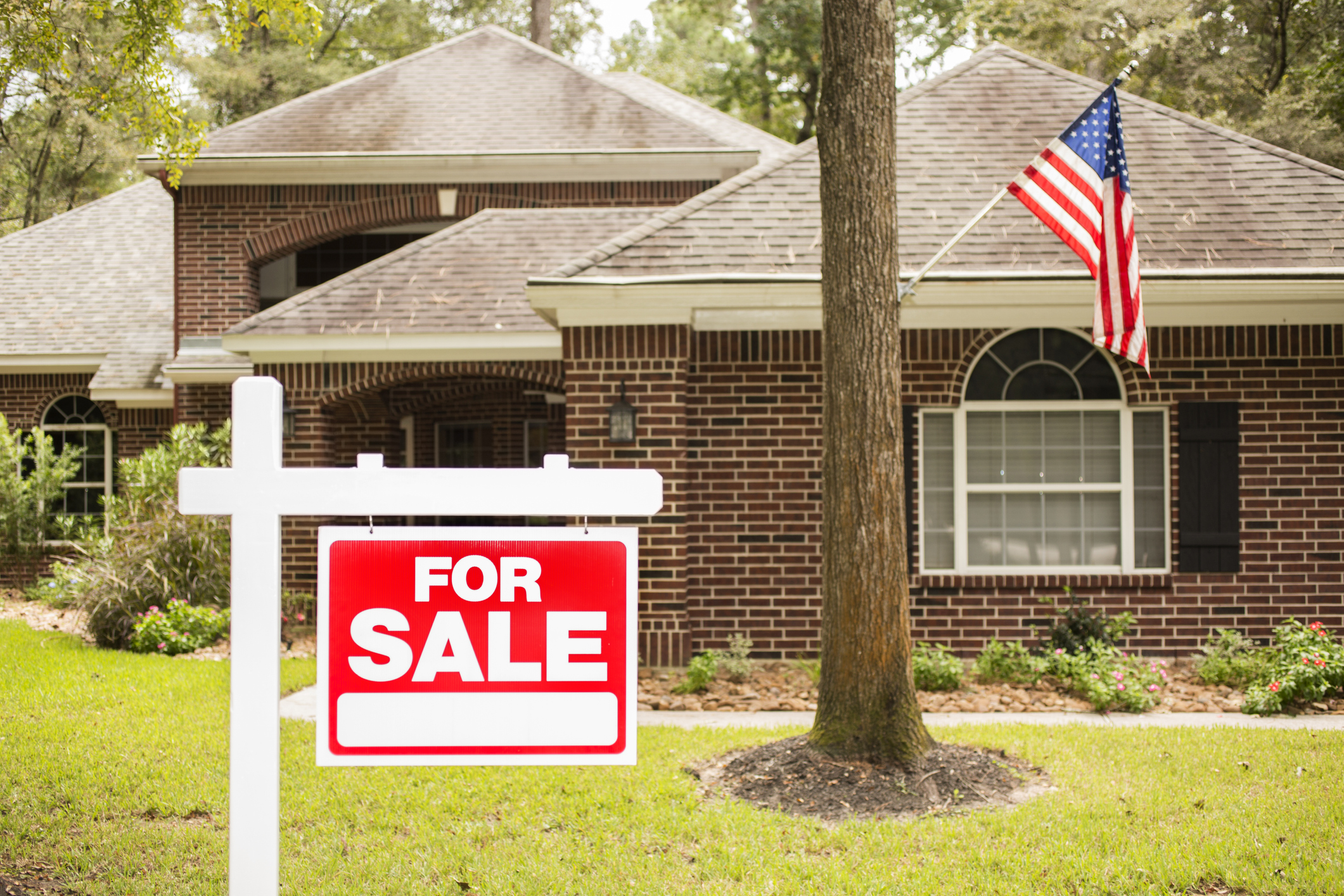 A house with a for sale sign in front of it.