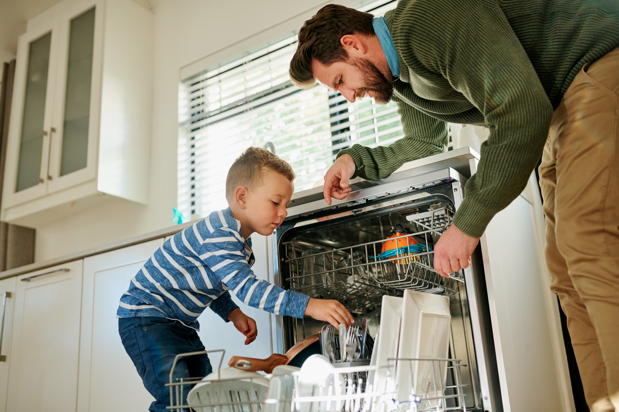 Parent and child loading a dishwasher