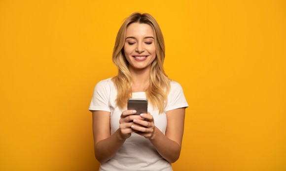 A person looking at a phone and smiling.