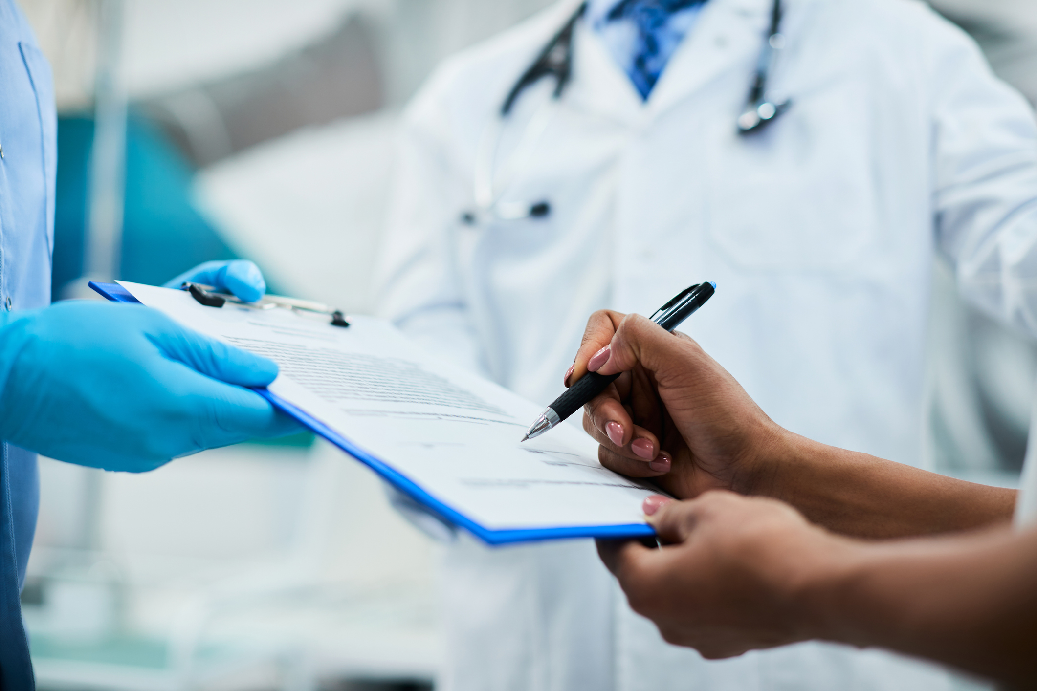 Person signing medical forms in a doctor's office.