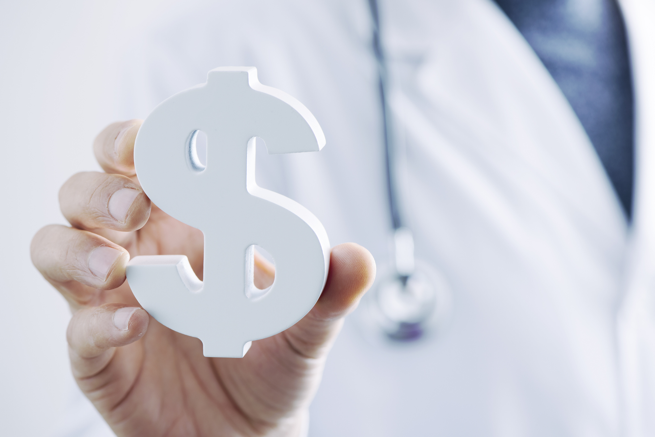 Medical professional holding dollar sign paperweight