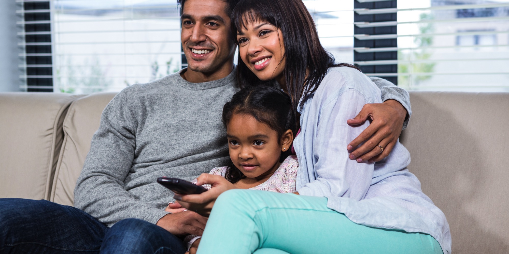 diverse family watching tv with child