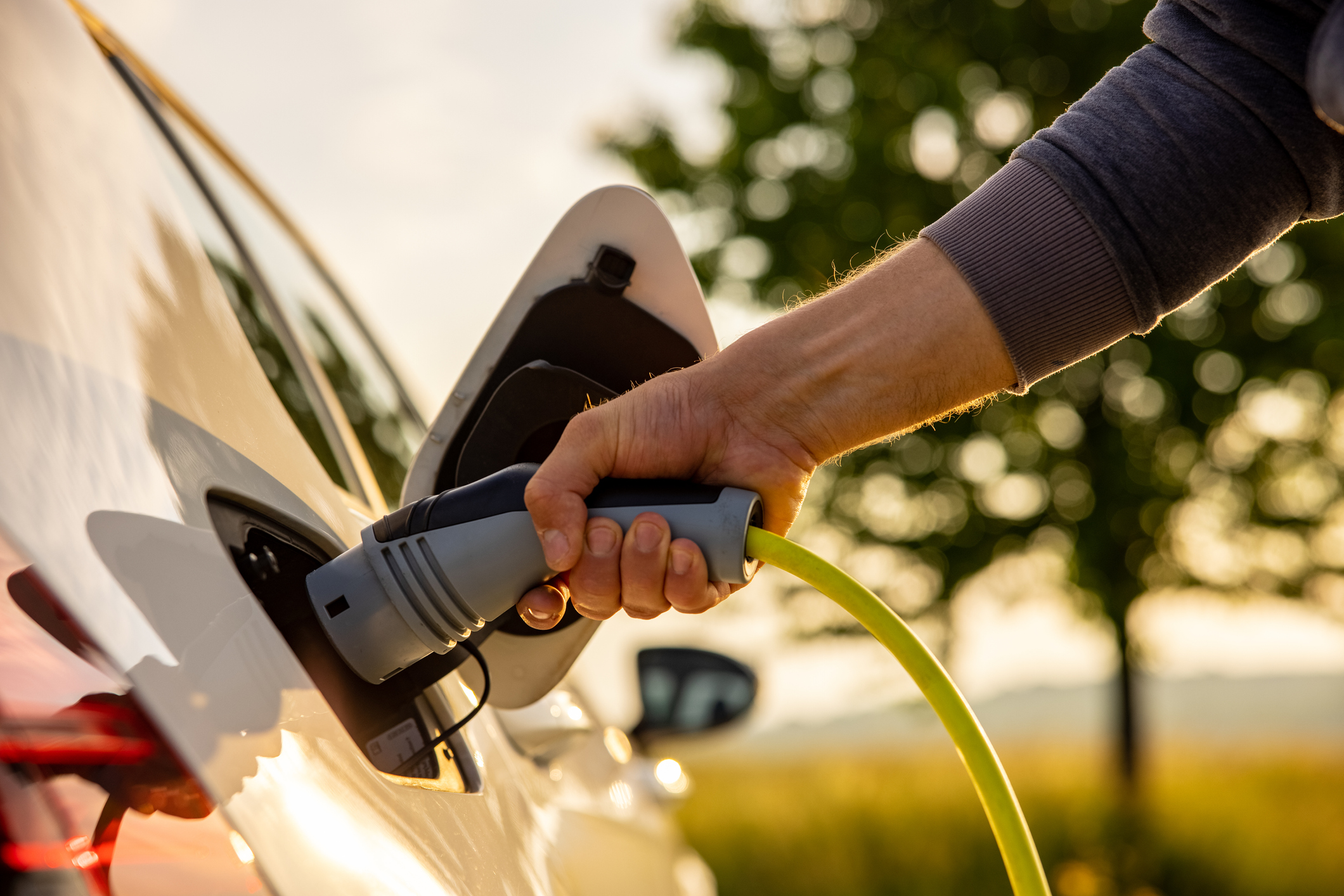A person plugging in an electric vehicle.
