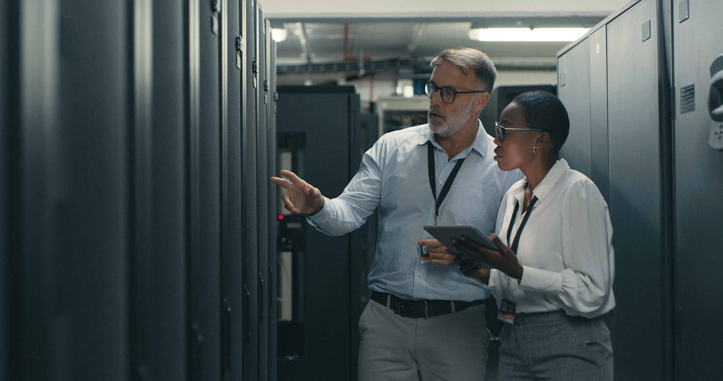 Two colleagues confiring in a server room