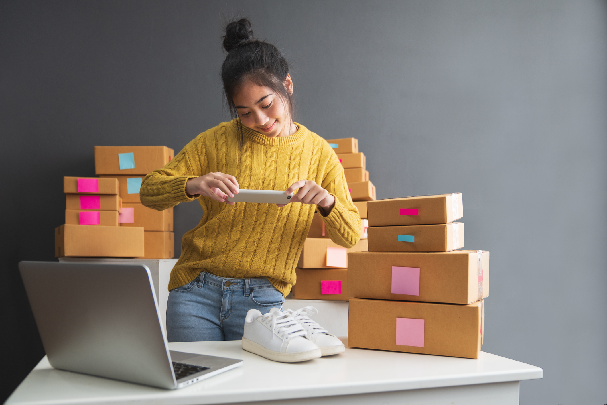 An online merchant takes a picture of a pair of shoes.