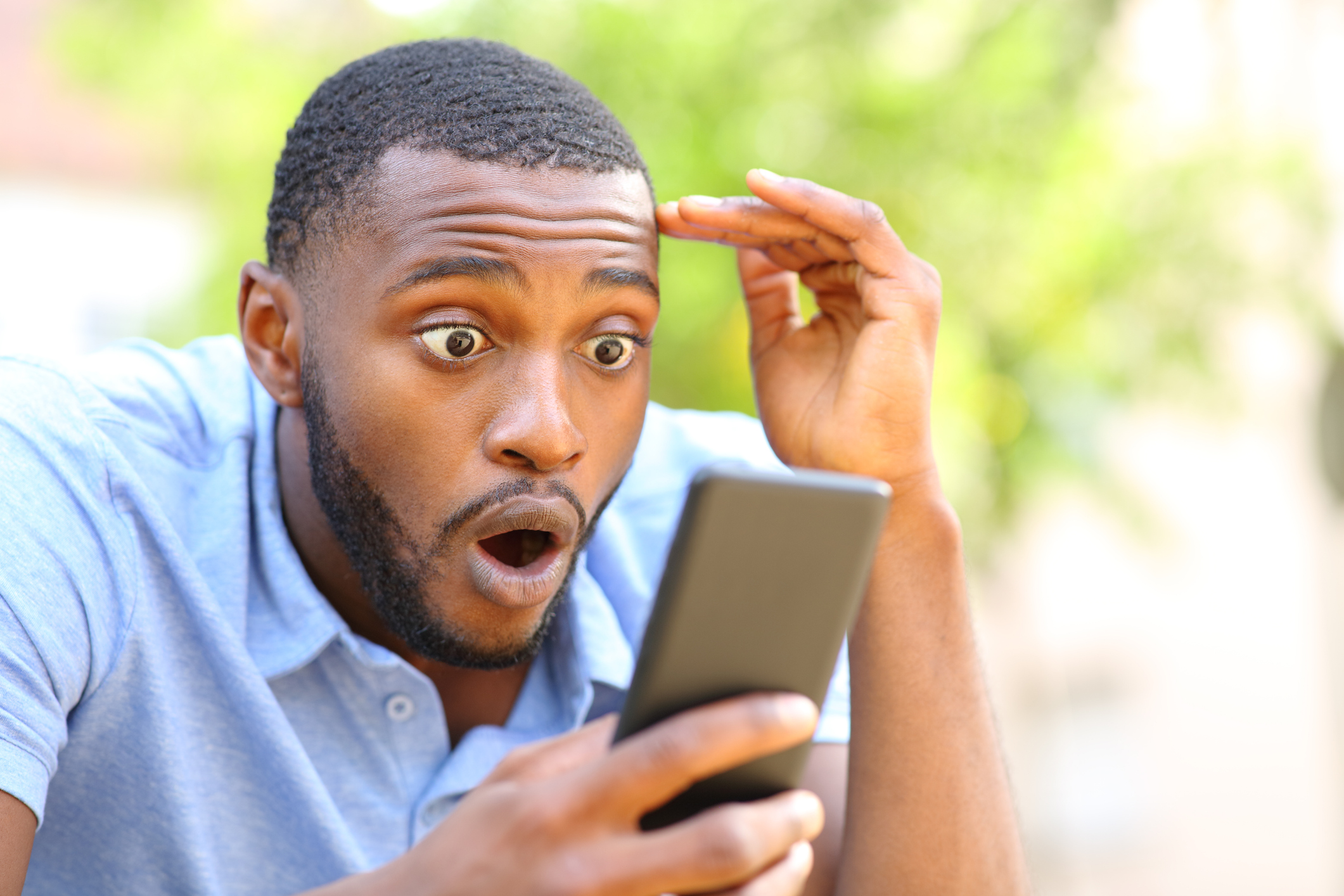 Person looking at their smartphone in shock