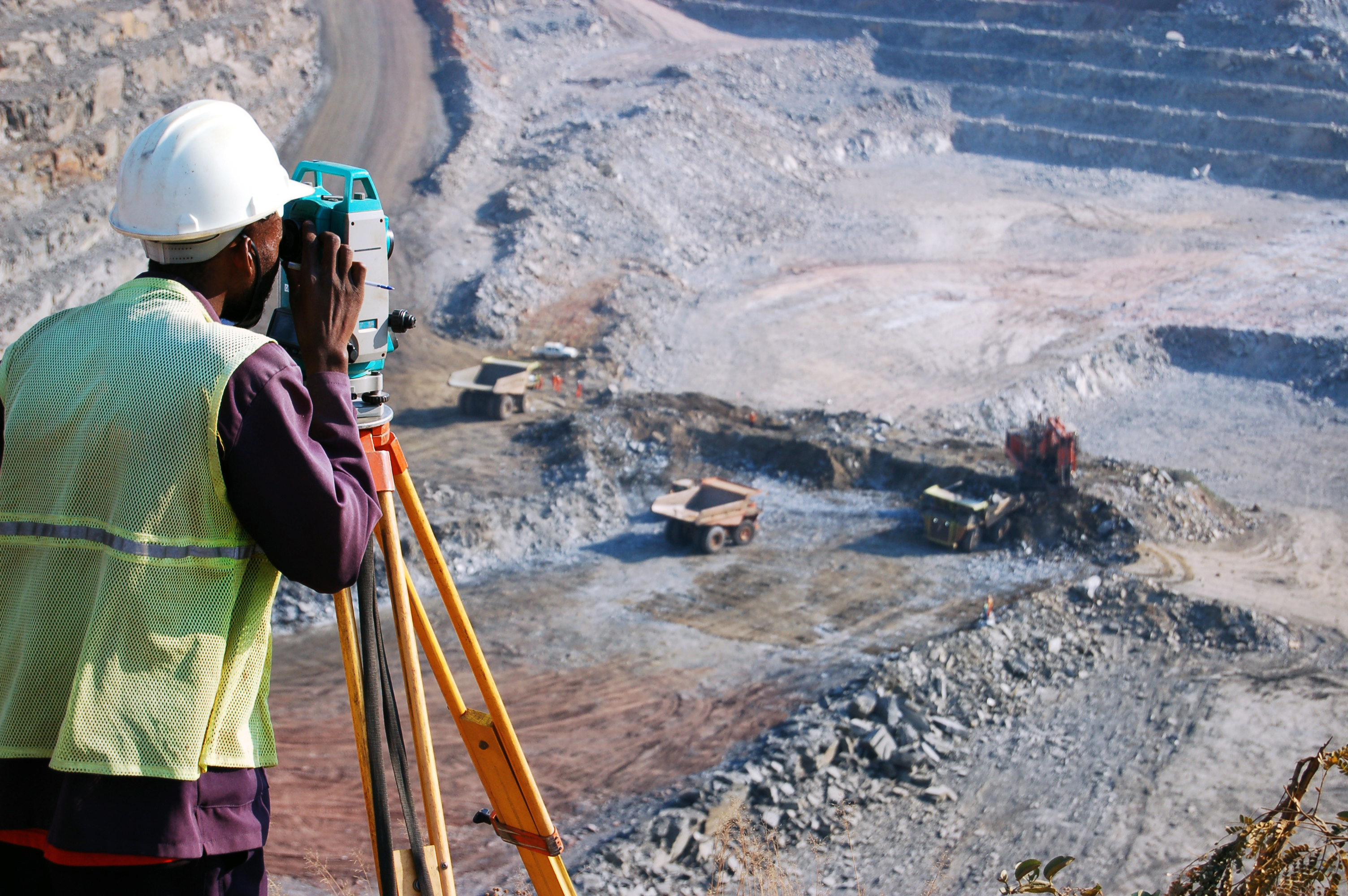 A surveyor works at an open pit mine.