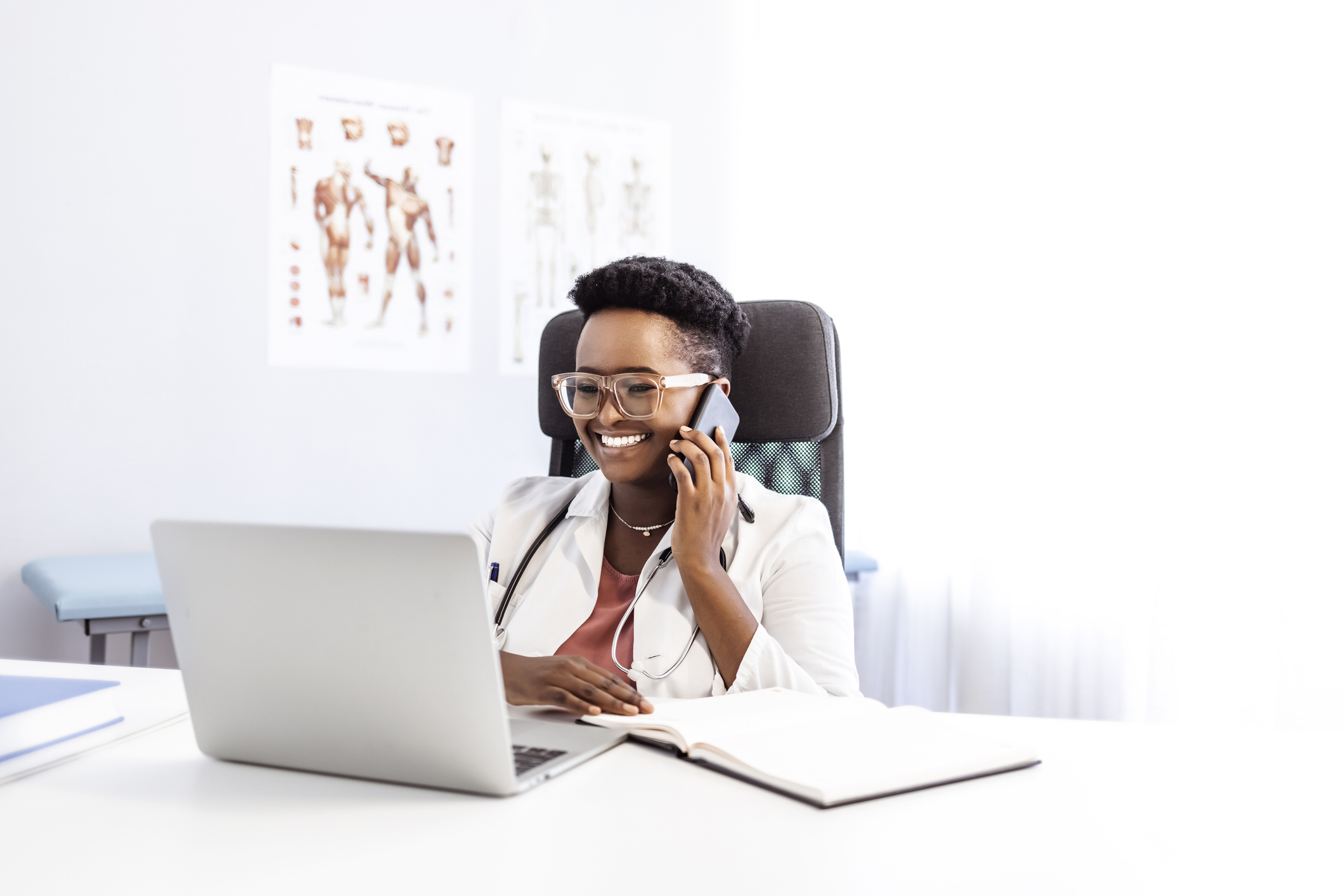 doctor does a telehealth visit with laptop and phone
