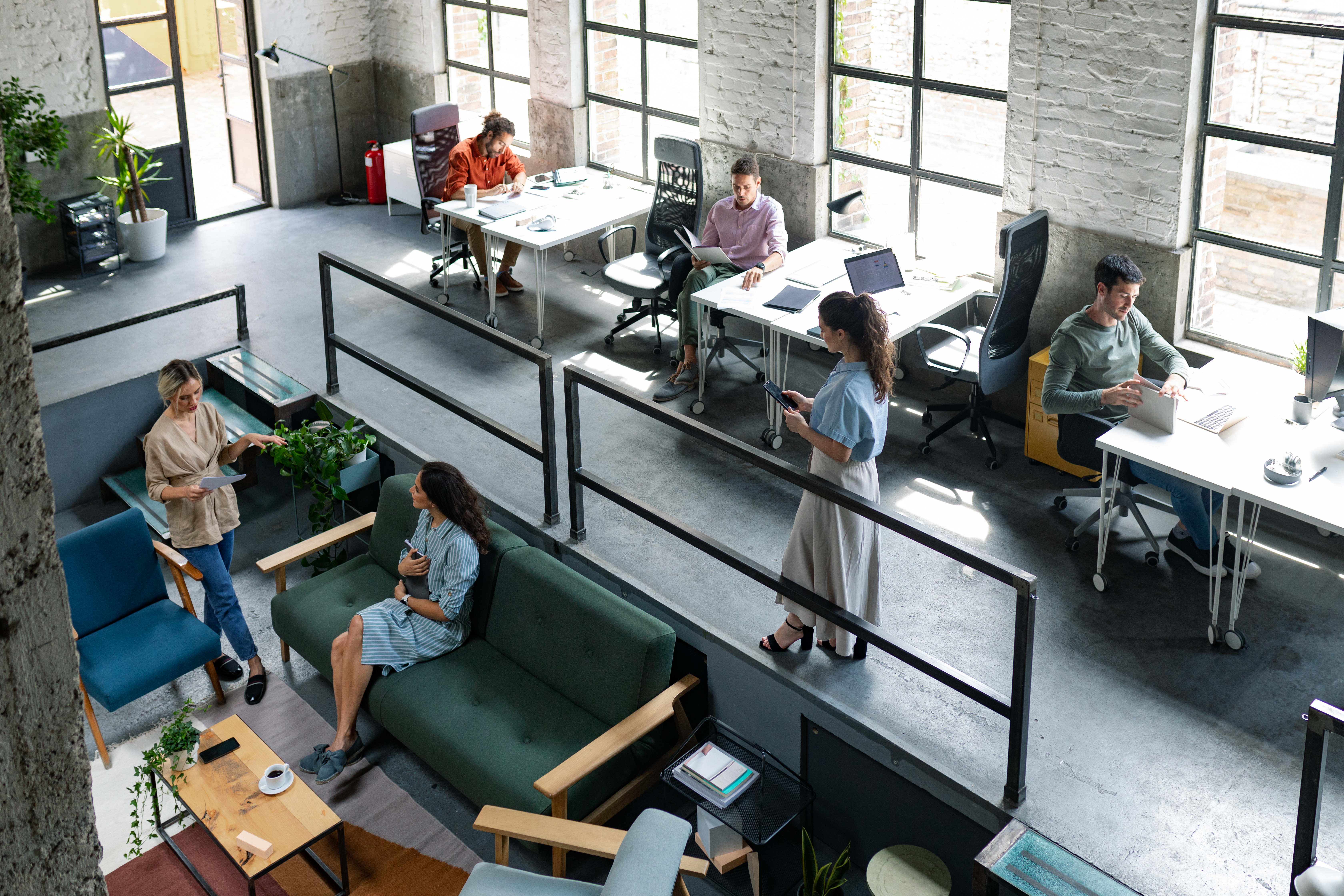 People chatting and working in and open office setting. 