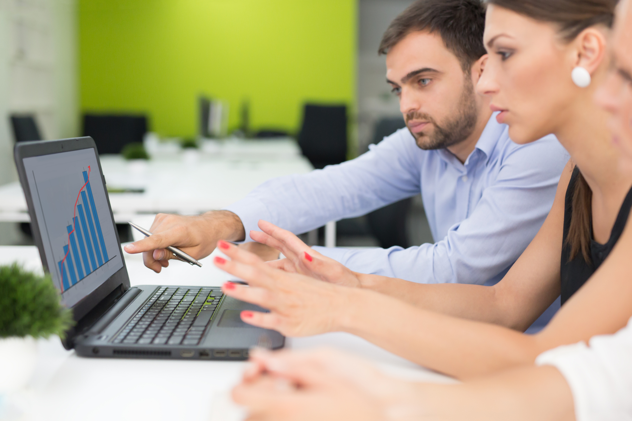 People looking at a chart on a laptop.