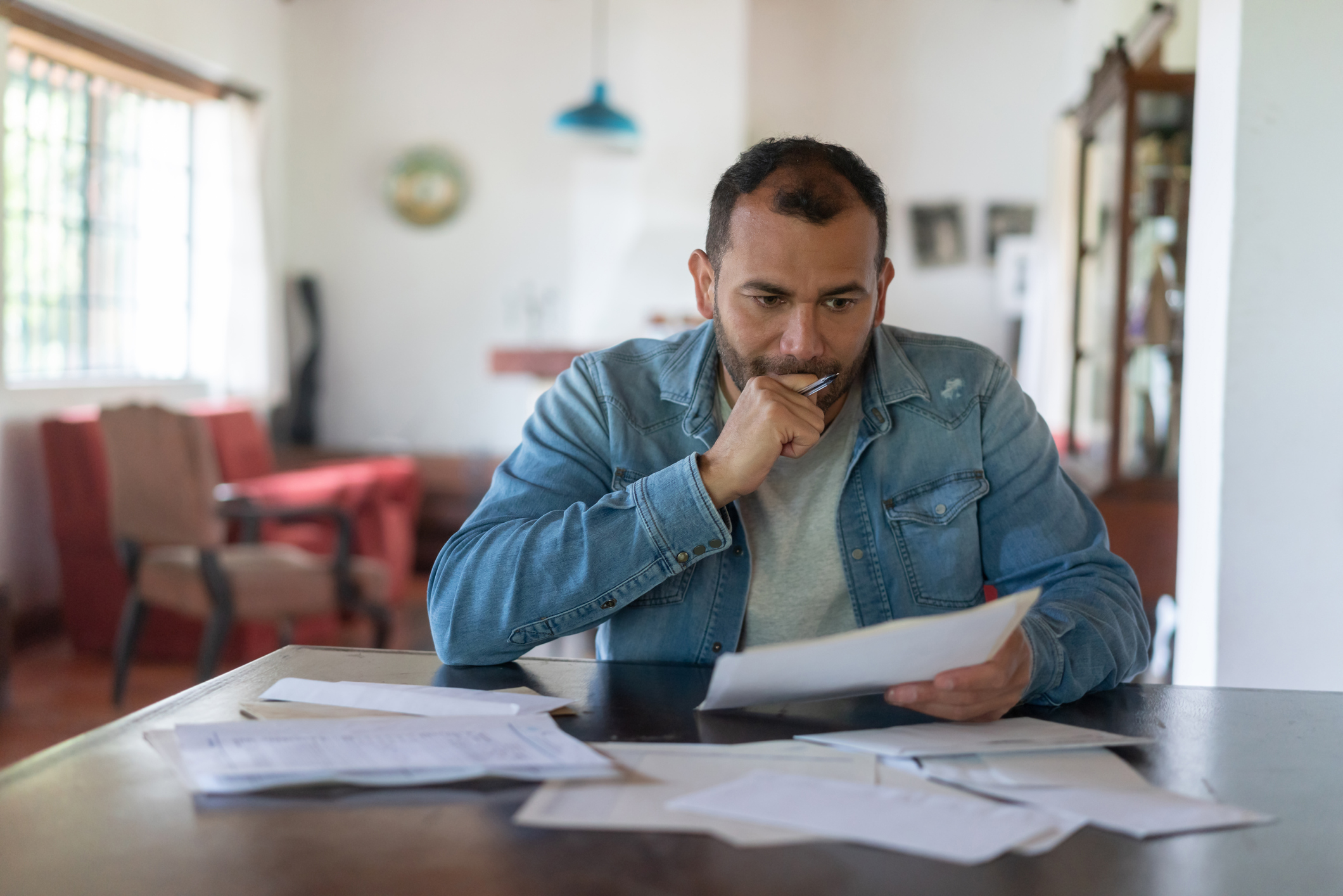 Investor at home considering investment options.