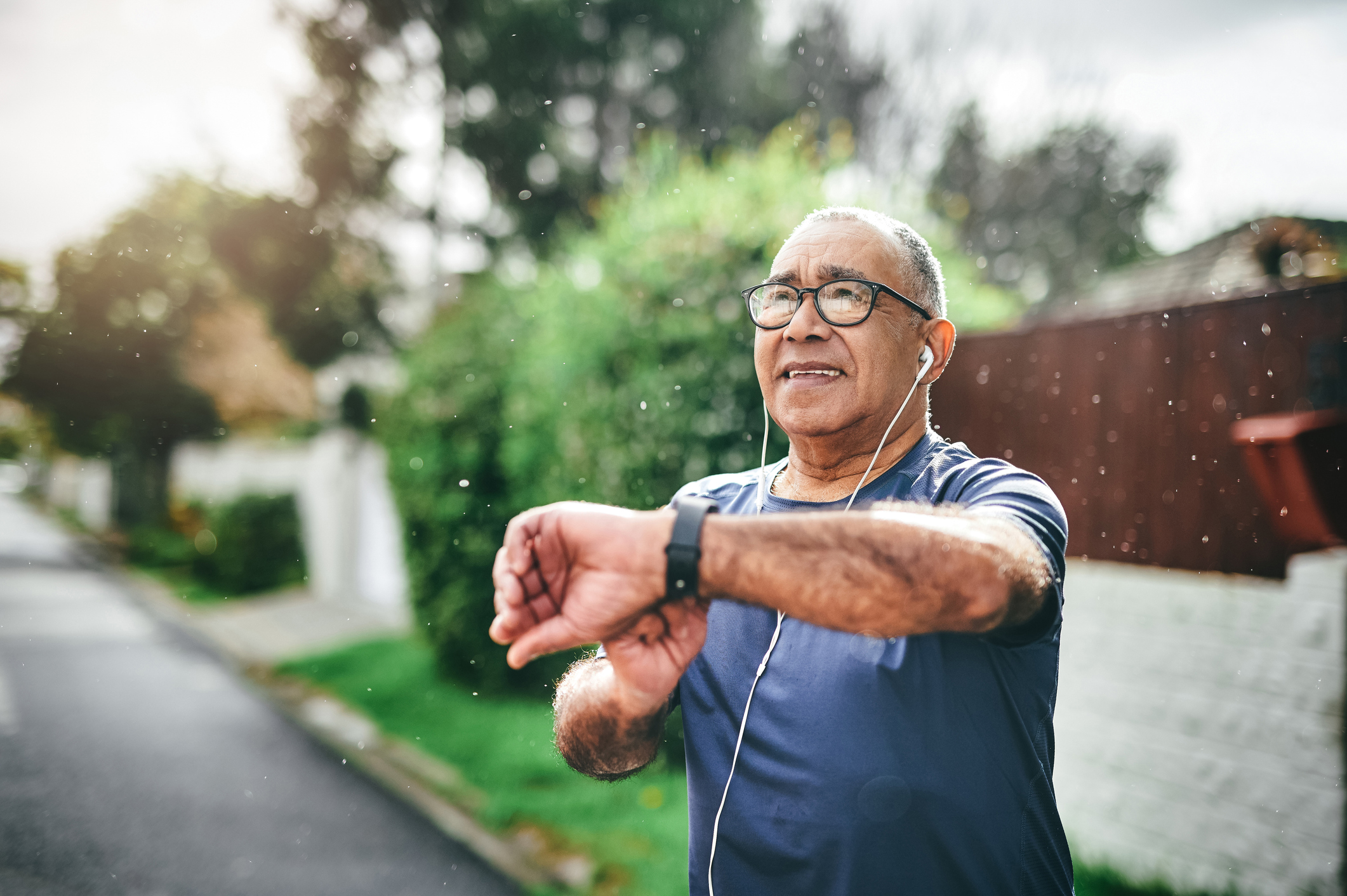 Person exercising outside and looking at a watch.