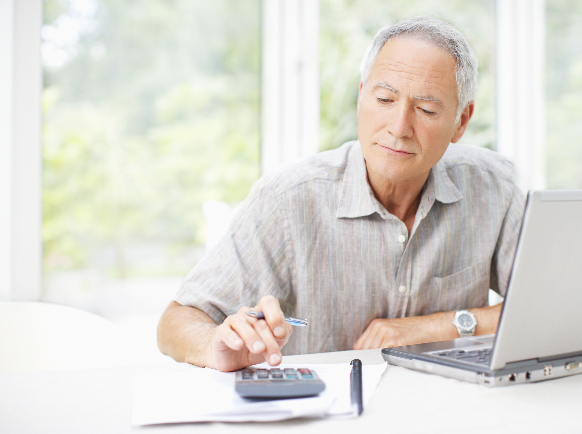 Senior man using calculator GettyImages-107071080