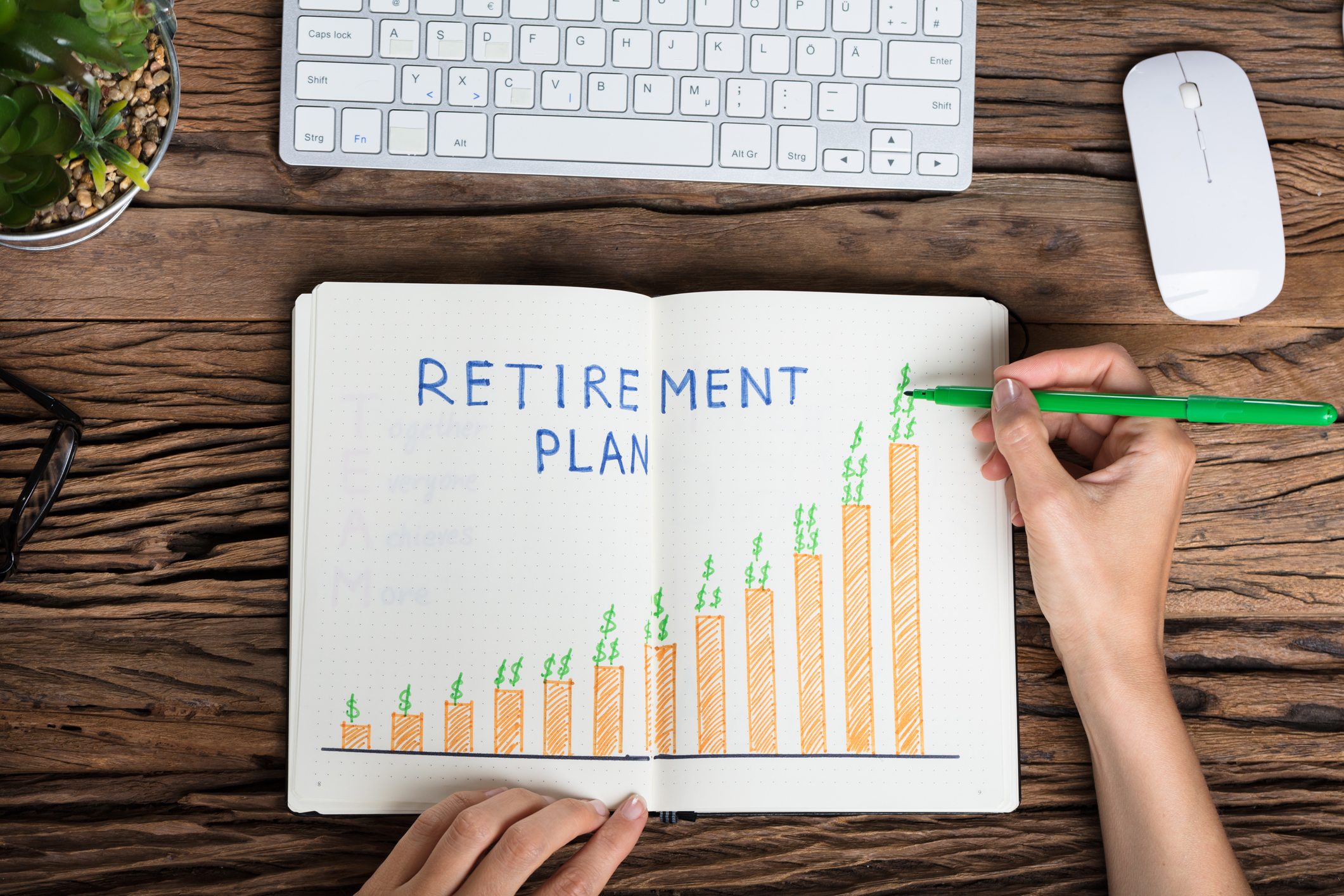 Person drawing a bar graph on a piece of paper with Retirement Plan written as the title.