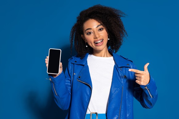 A person points to a smartphone.