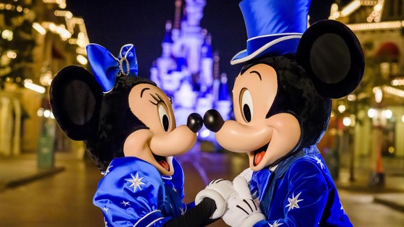 Mickey and Minnie Mouse touch noses on Main Street.