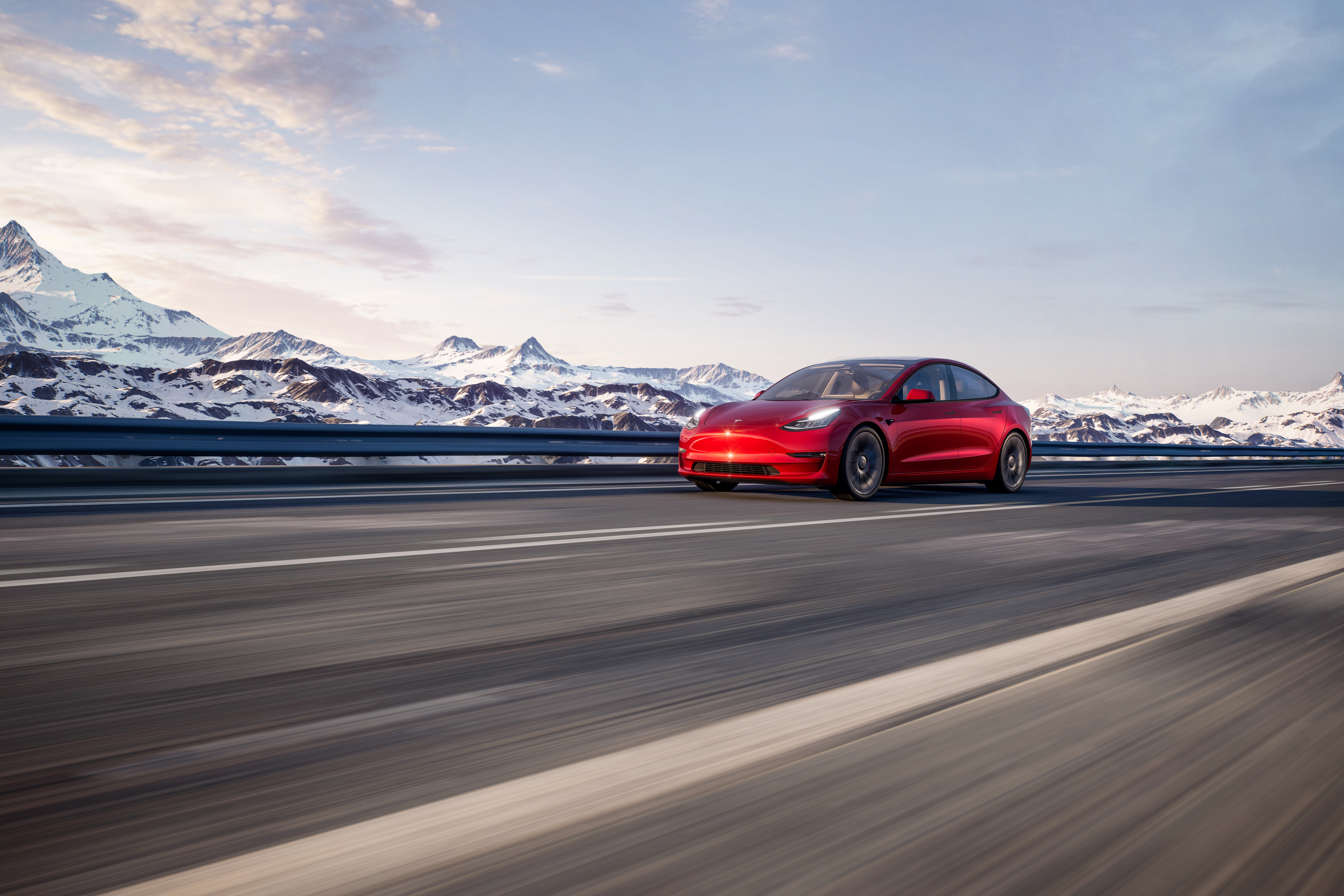 red Tesla Model 3 with snowy mountains in background.