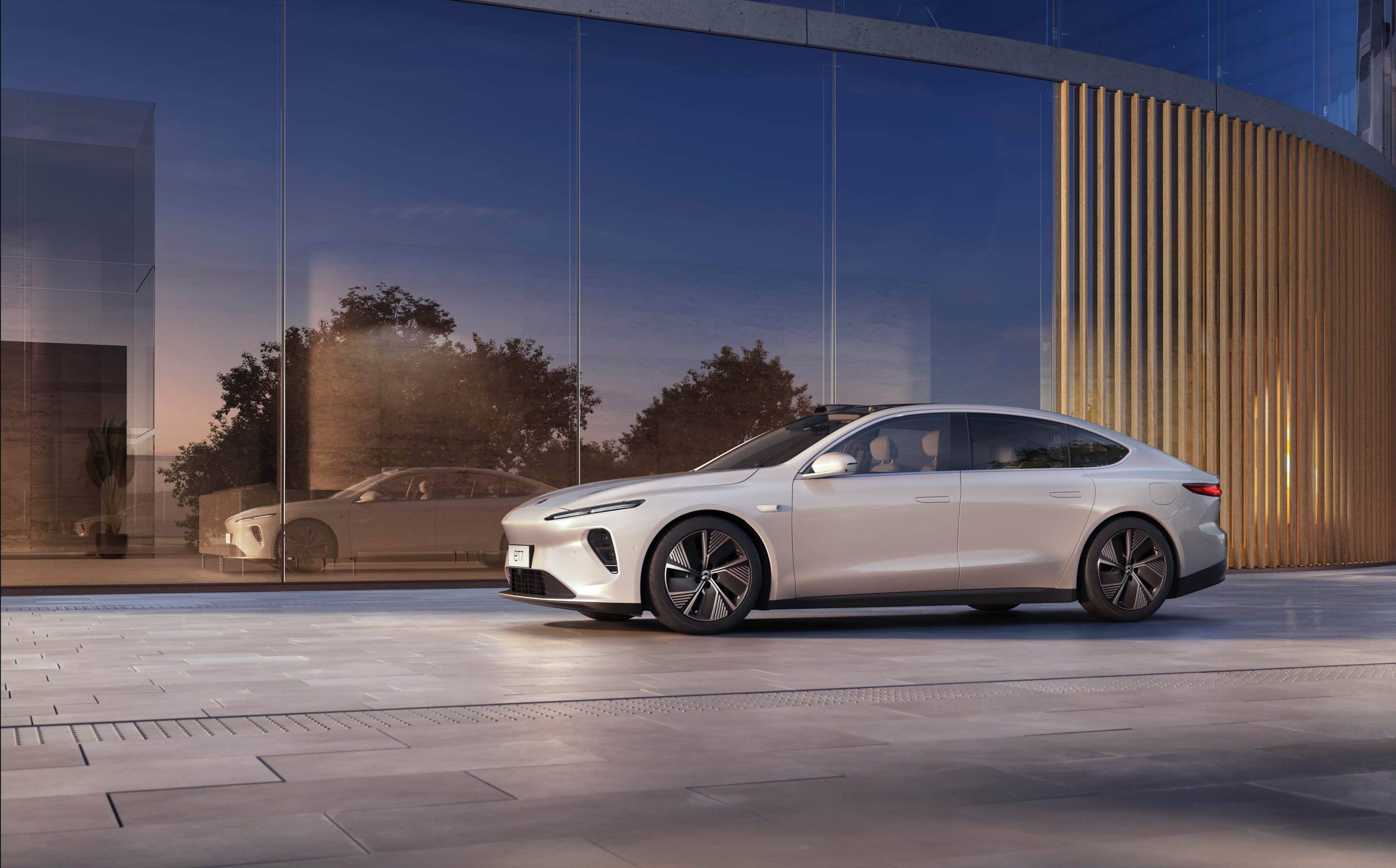 Nio ET7 sedan in front of glass wall.