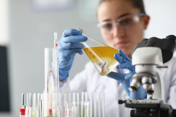 Scientist mixing chemicals in a beaker.