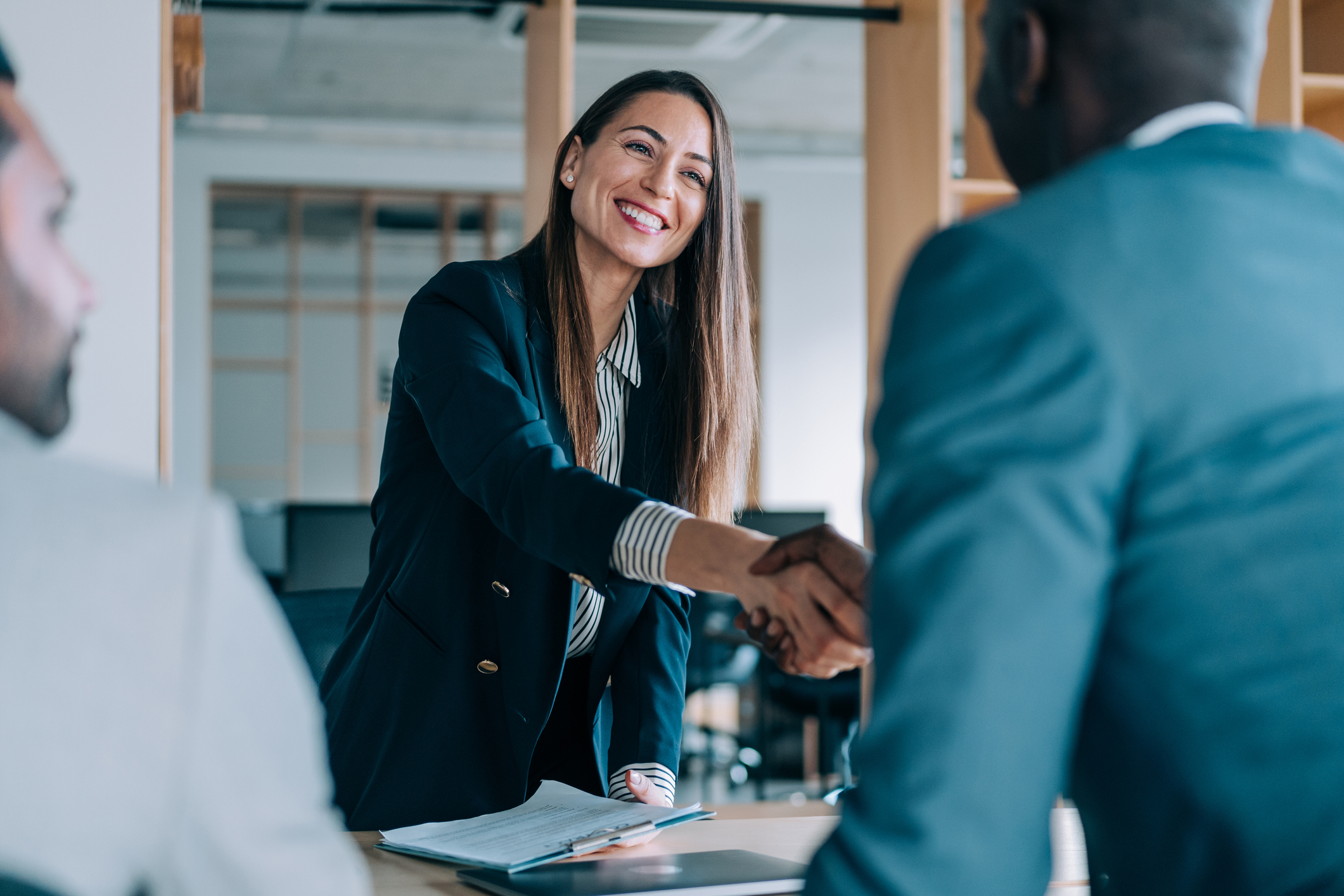 Businesspeople shaking hands in office.