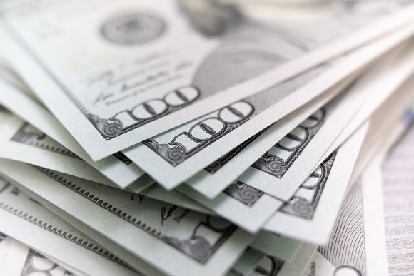 A slightly askew stack of one hundred dollar bills. 