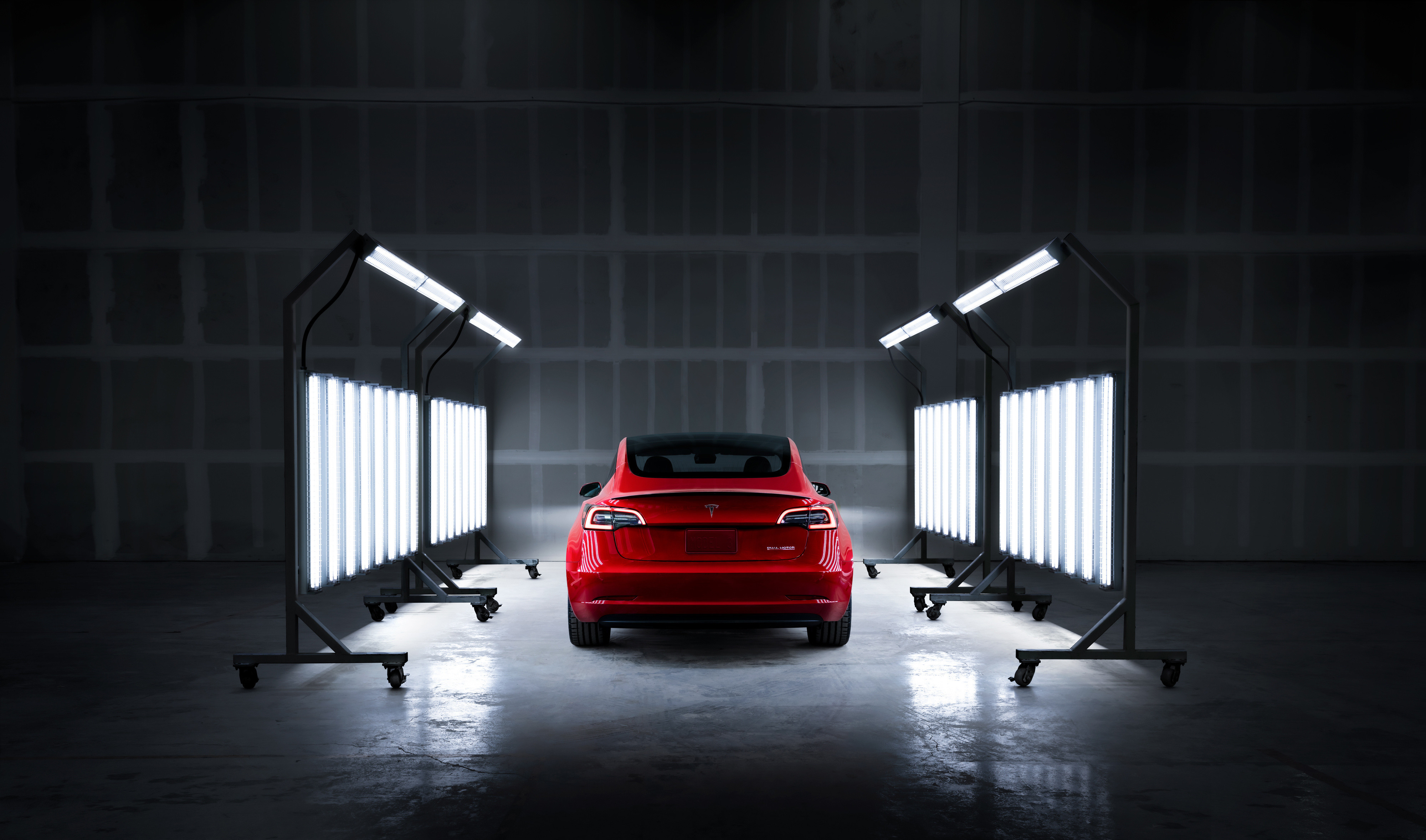 red Tesla in brightly lit shop area.