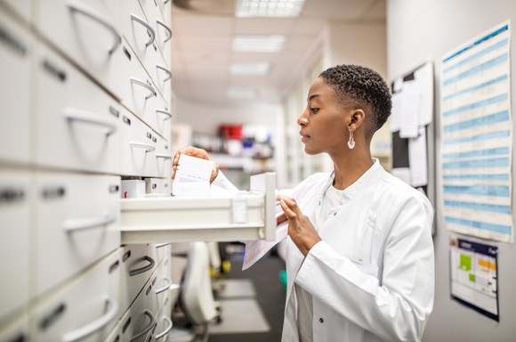 A pharmacist looking in a drawer.