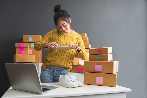 An online merchant takes a picture of a pair of shoes.