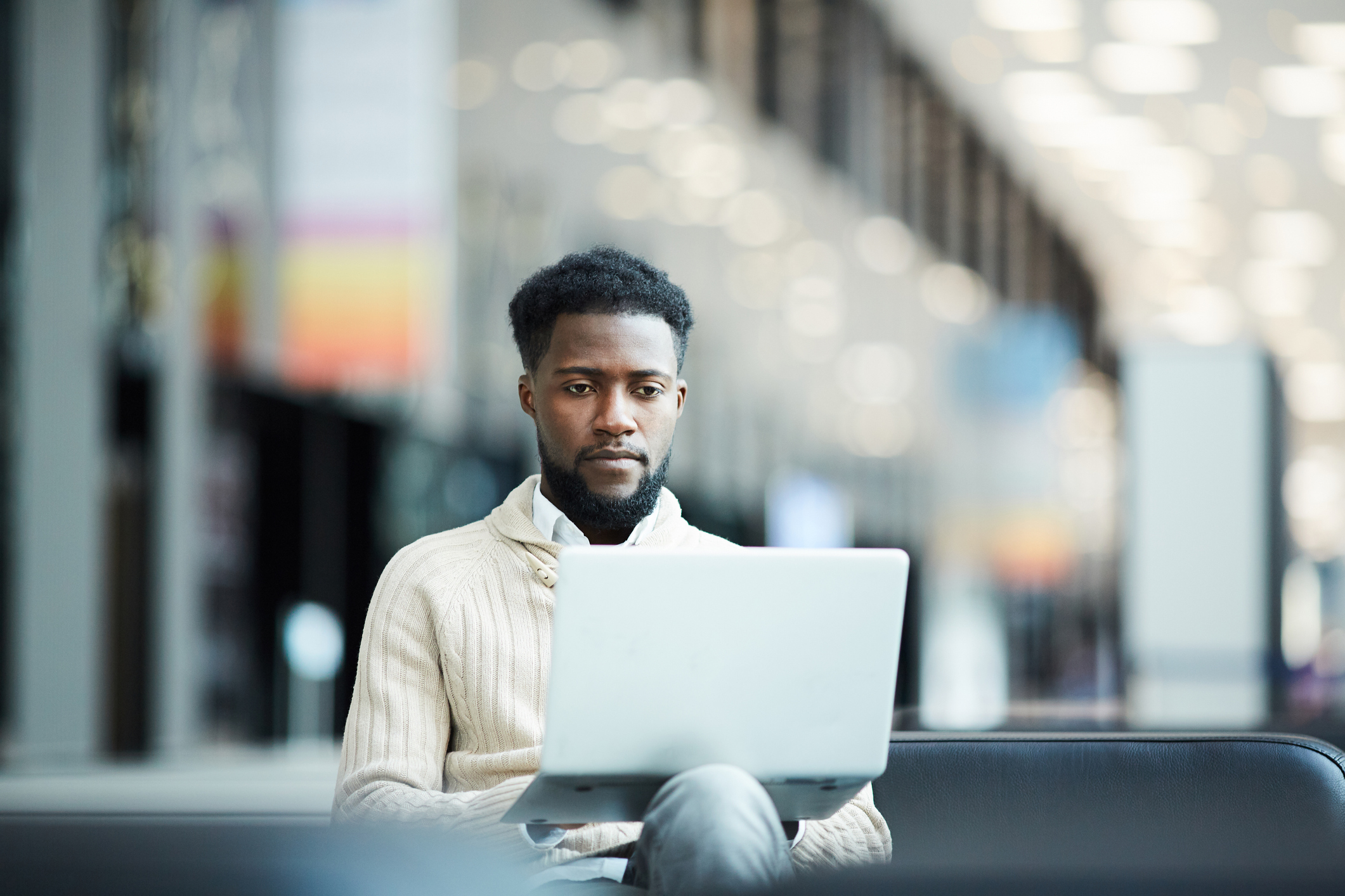 A person at a laptop with a serious expression.
