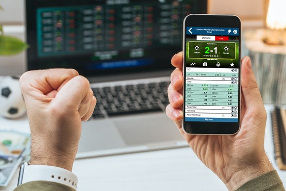 A person places a sports bet on their phone.
