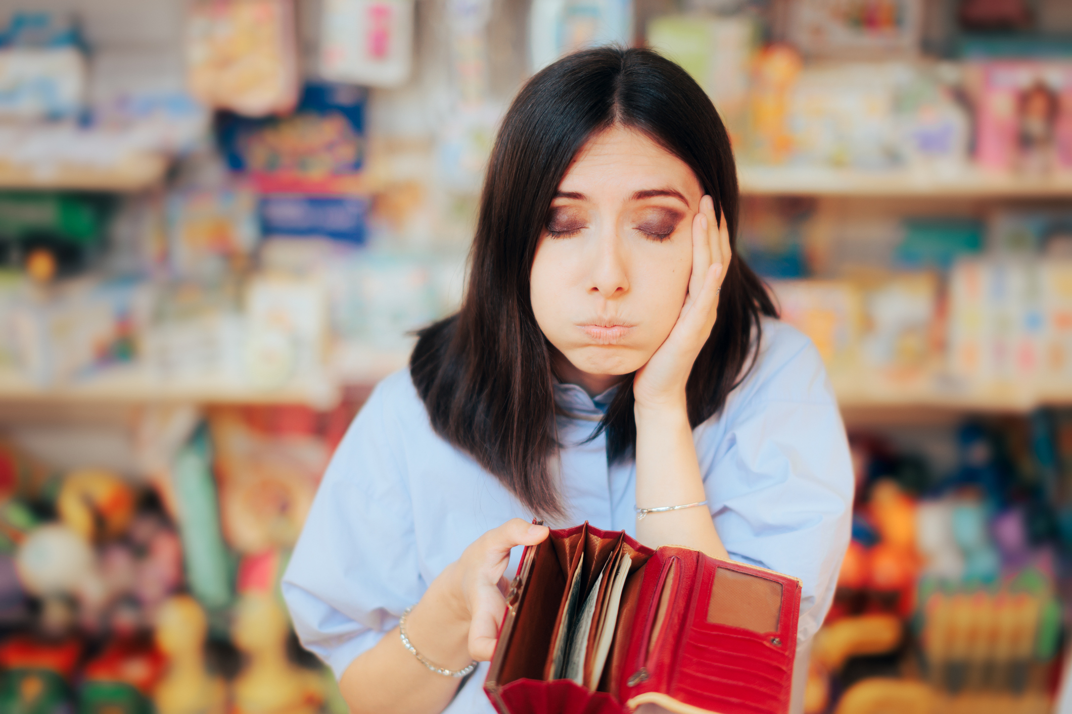 Worried person looks at wallet in a store.