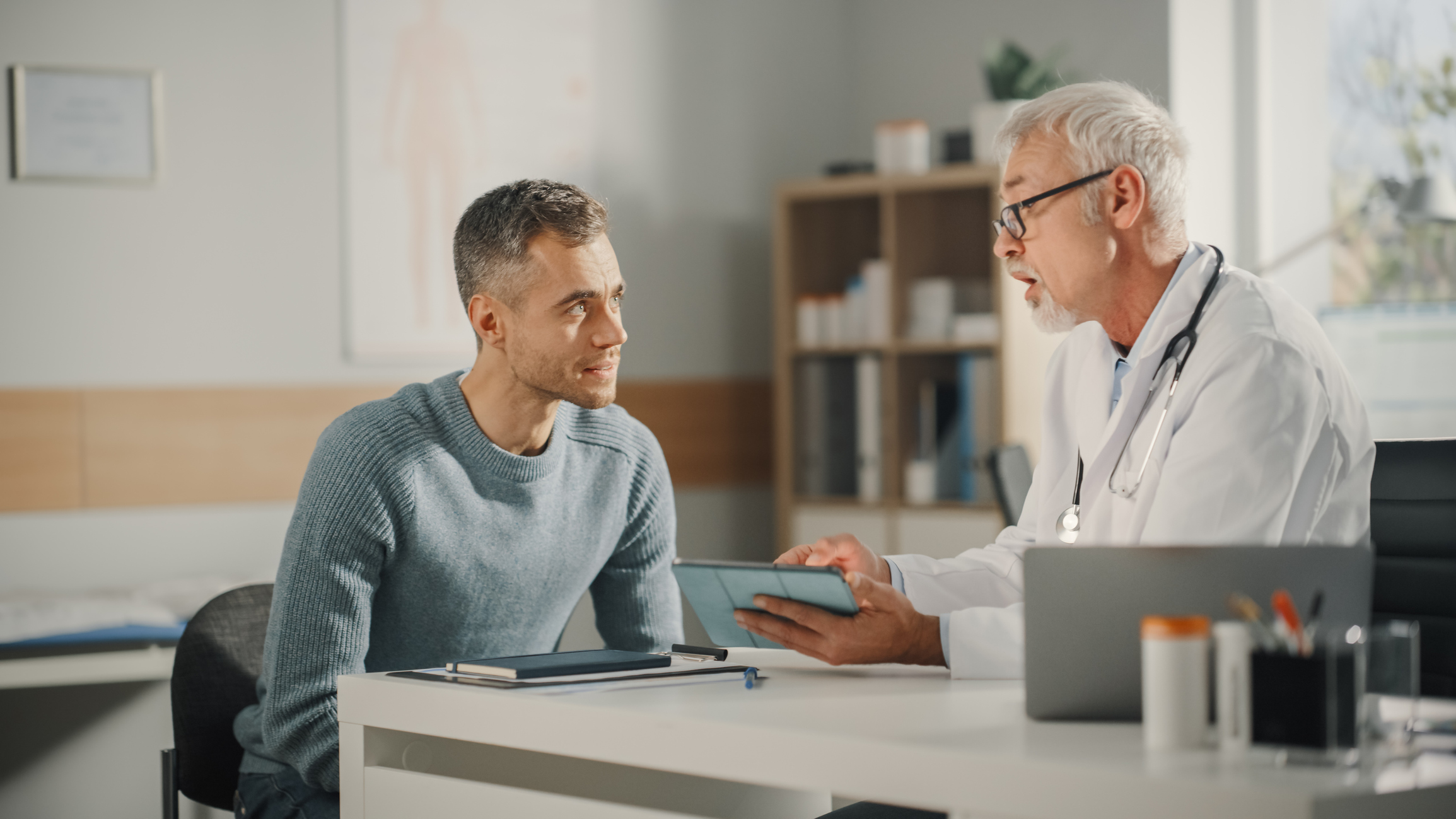 A doctor talking to a seated person.