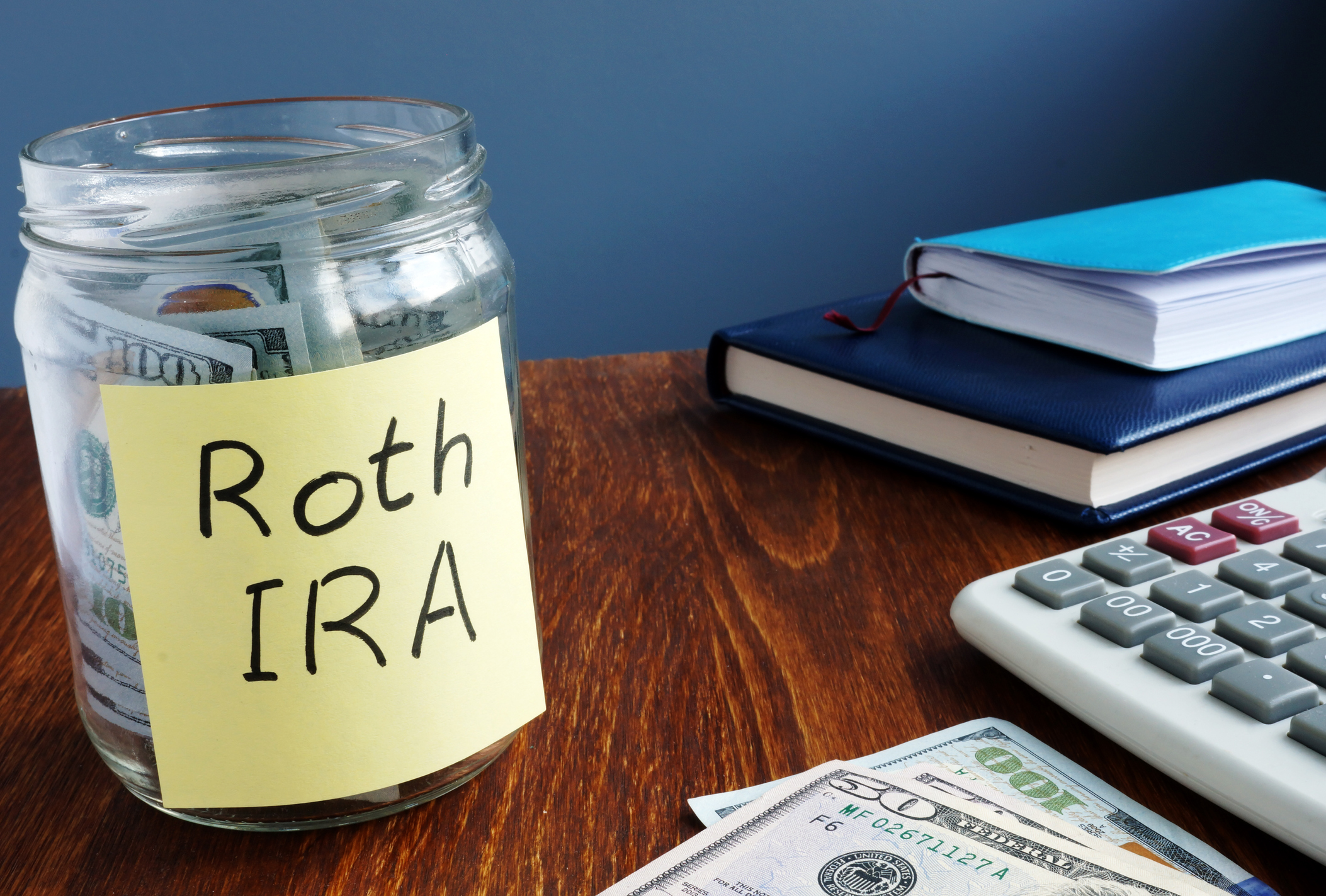 A jar marked Roth IRA stuffed with money.