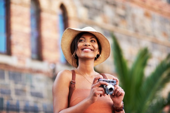 A smiling person holding a camera.