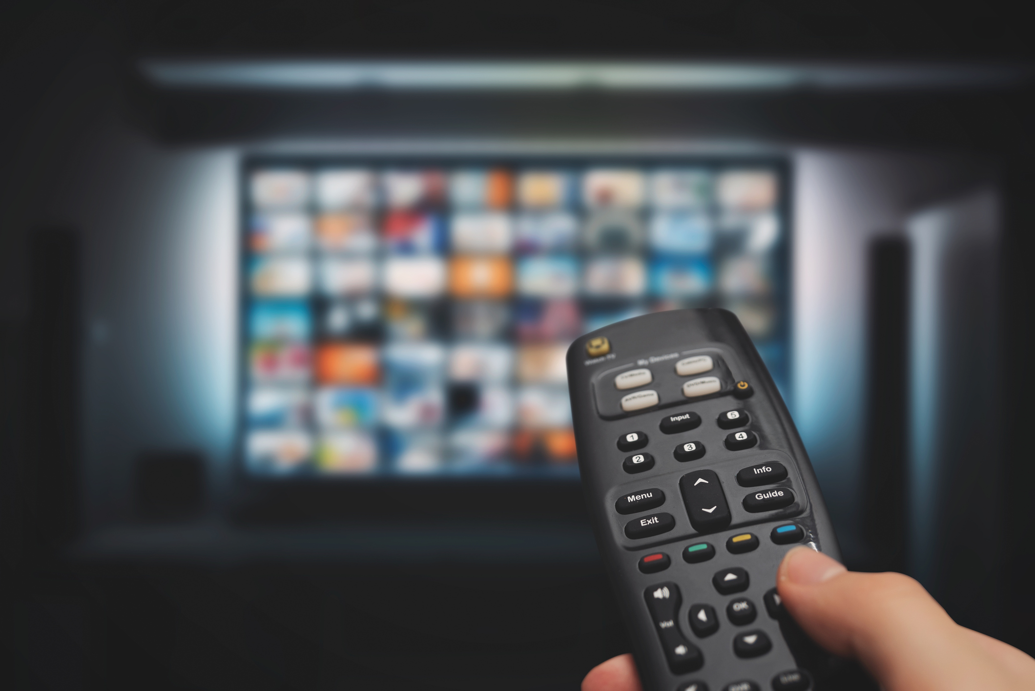 A hand holding a TV remote.