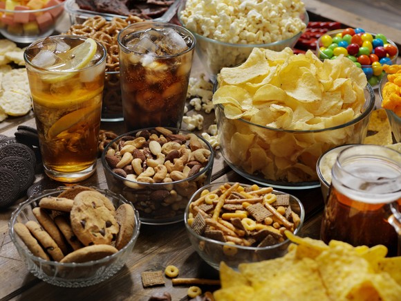 A number of snacks and soft drinks on a table.