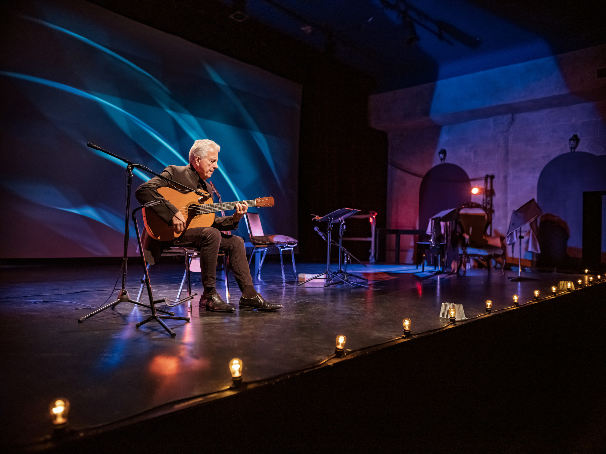A person playing guitar on stage.