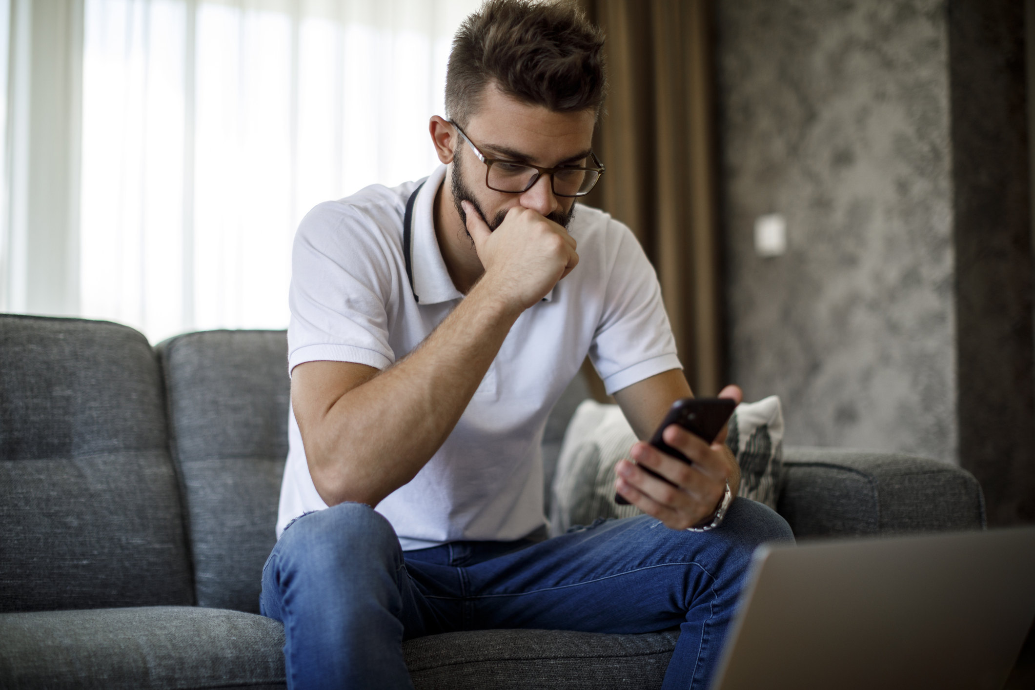 A person sitting on a couch looking at a phone.