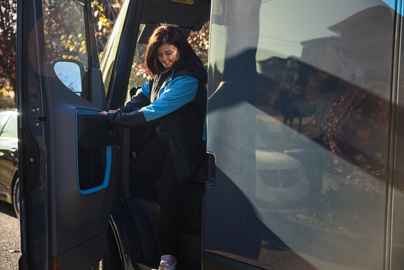 Amazon driver exiting a delivery truck.