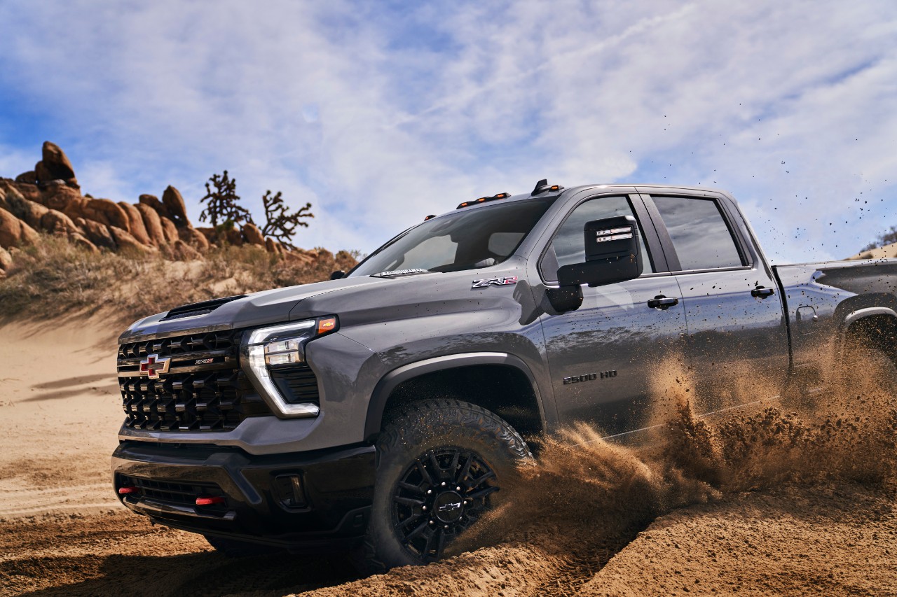 A 2024 Chevy Silverado HD ZR2 driving on a dirt terrain.