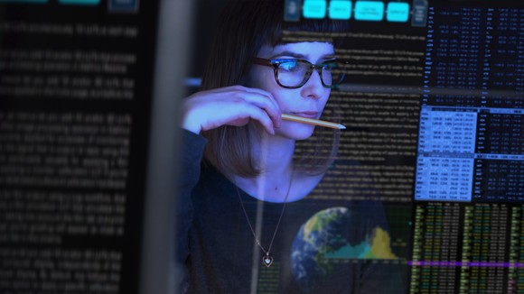 An IT professional checks a computer monitor.
