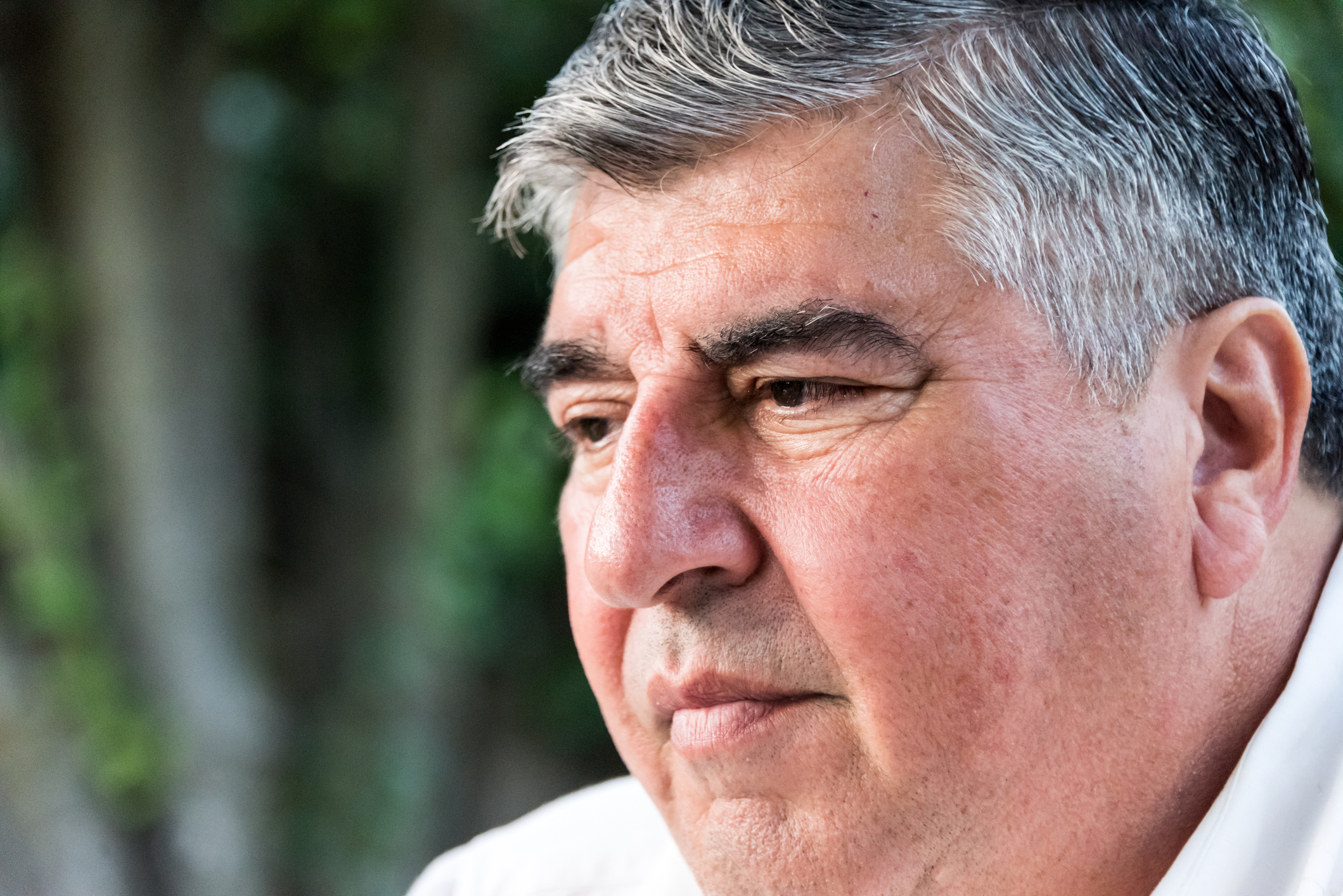 We see a close up of a person's face as he looks a bit unhappy.