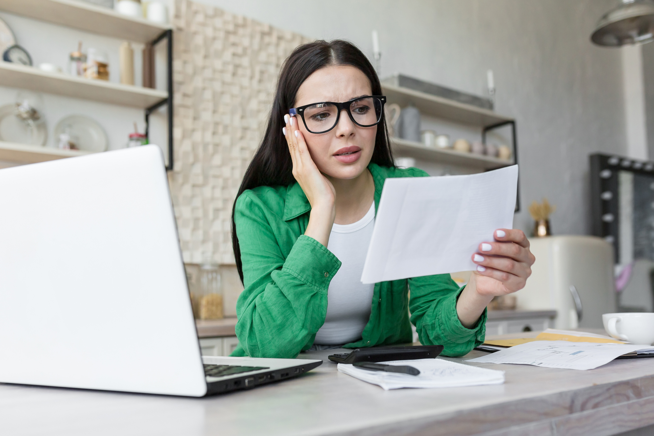 A person at a desk holding a document.