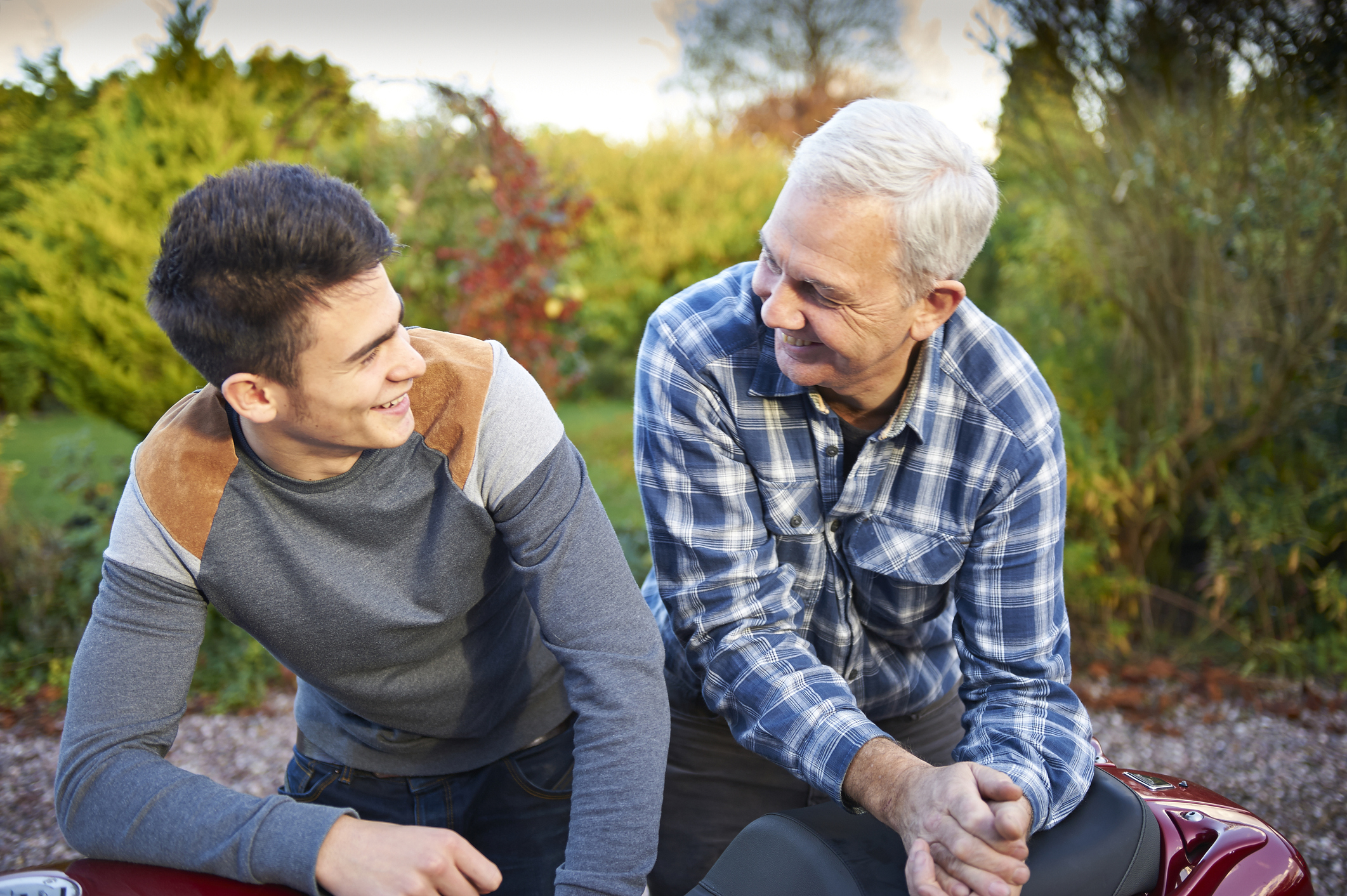 Young person and older person talking outside.