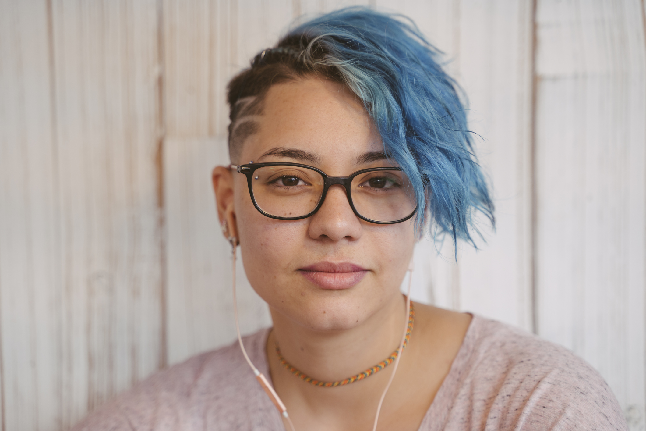 Person with blue hair and a slightly serious expression.